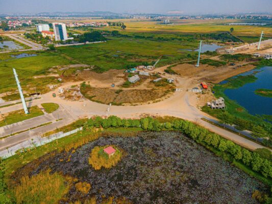 Flycam công trường hạ tầng tại phường Kinh Bắc – khu vực KĐT Vinhomes Bắc Ninh; thấy nền đường, nút giao, máy móc thi công, cột chiếu sáng và hồ nước.